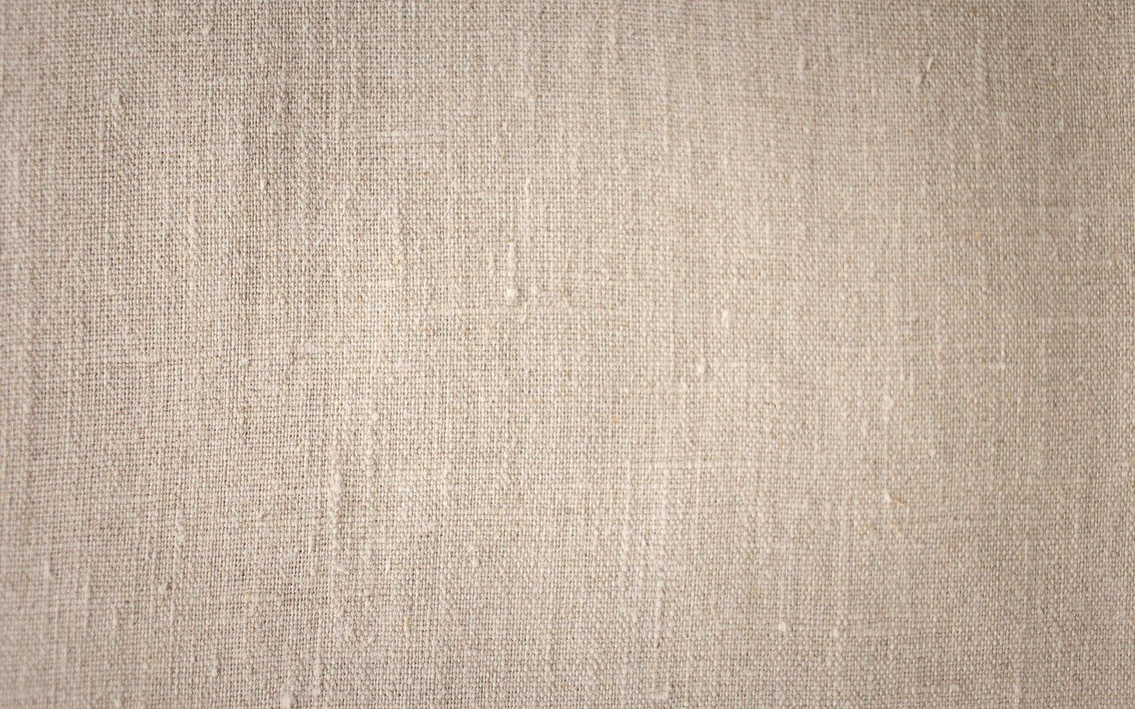 Close-up of woven natural linen fabric showing its textured, uneven threads